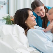 A mother holding up her baby post partum with nurse, happy!