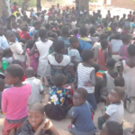 A large group of children in Malawi suffering from a hunger crisis.